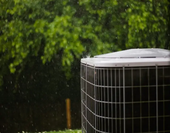 Outdoor air conditioning condenser beside a home